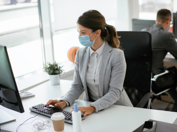 Person workiing iin an office with face mask on