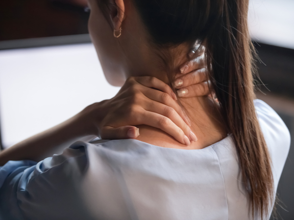 Woman rubbing her neck at her desk