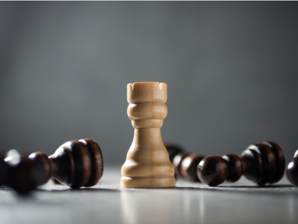 Chess Rook standing among fallen pawns