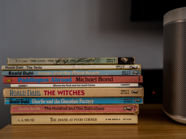 Stack of children's books next to speaker