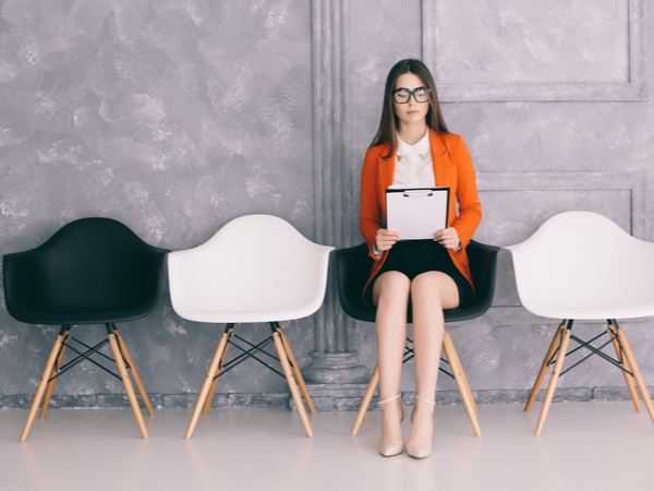 Young woman sitting on a chair in a waiting room before an interview