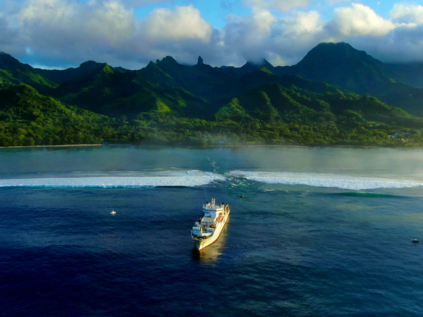 A ship sailing towards one of the Pacific Islands