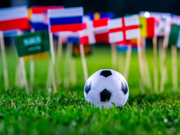 A toy football in front of minitature flags of different countries