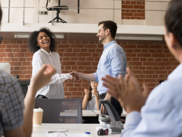 Two people talking and welcoming new starter at work