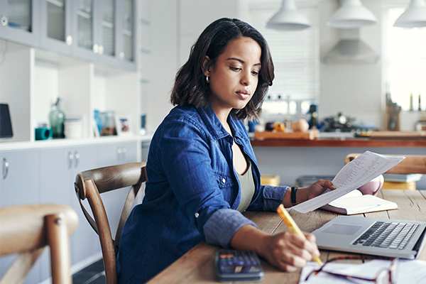 Young woman at desk with papers and laptop