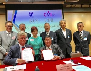 Photo commemorating signing of CMI-KCC Alliance in 2014 on souvenir sheet