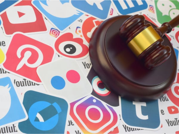 A gavel on a background of social media logos