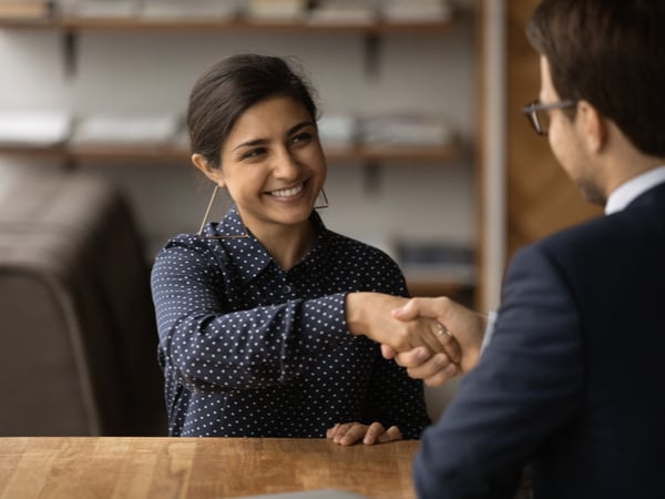 Young grad shaking hands to accept job offer