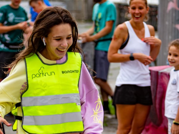 A Parkrun volunteer in a high-vis vest