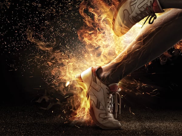A sprinter wearing trainers with flames coming out of them