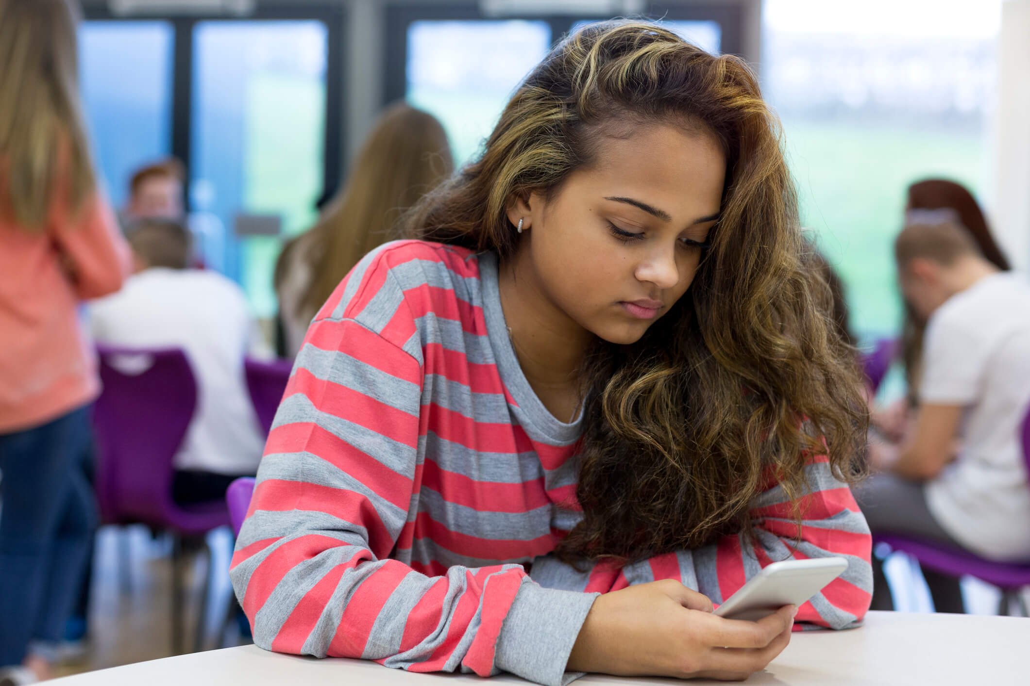 Homesick student sat looking at phone on Kooth Student