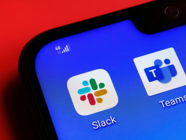 An image of a smartphone with app icons for Slack and Microsoft Teams on the screen