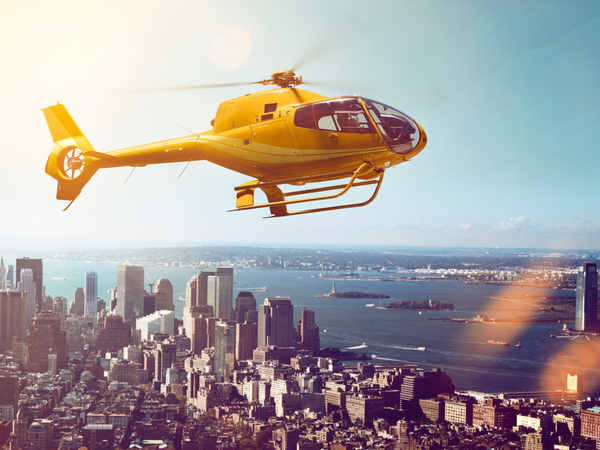 An image of a yellow helicopter flying over Manhattan