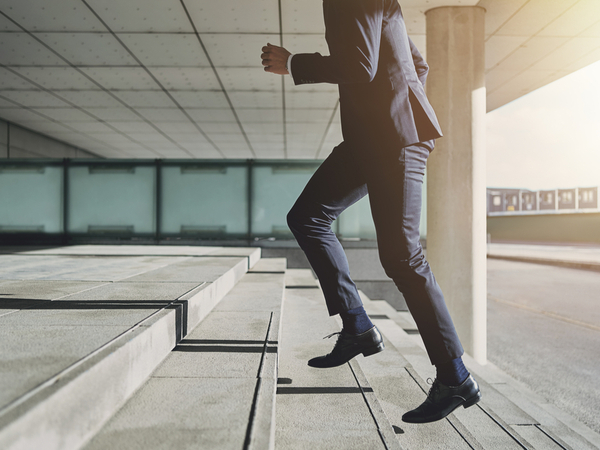 A man walking up the stairs of an office building