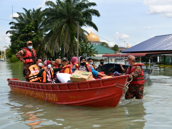 The Malaysian Fire department evacuating flood victims in a red boat