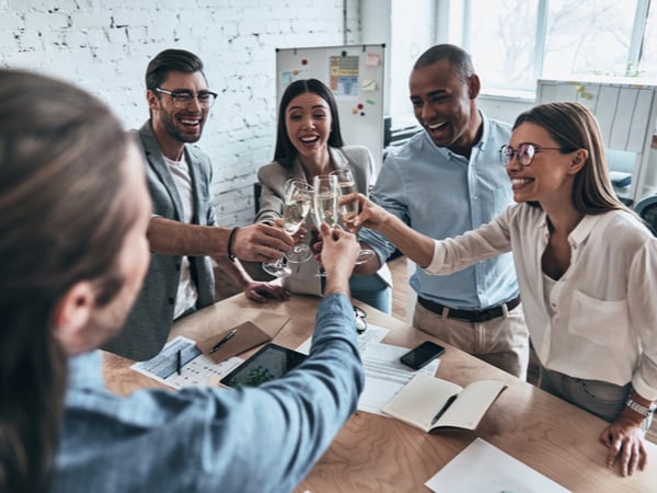 A group of colleagues clinking champagne glasses