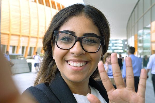 A woman filming herself and waving at the camera