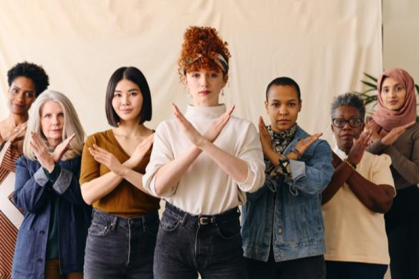 A group of women crossing their arm in a cross shape in front of them