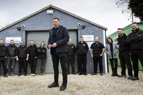 Tobyn Brooks standing with his employees outside the company garage