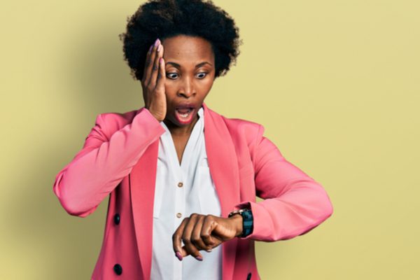 A woman looking shocked while looking at her watch