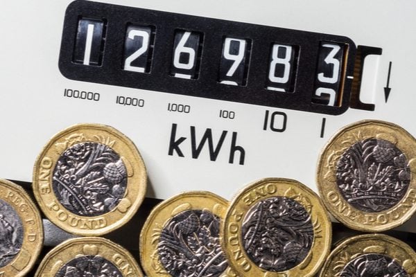 Pound coins next to a electricity meter whose numbers are increasing