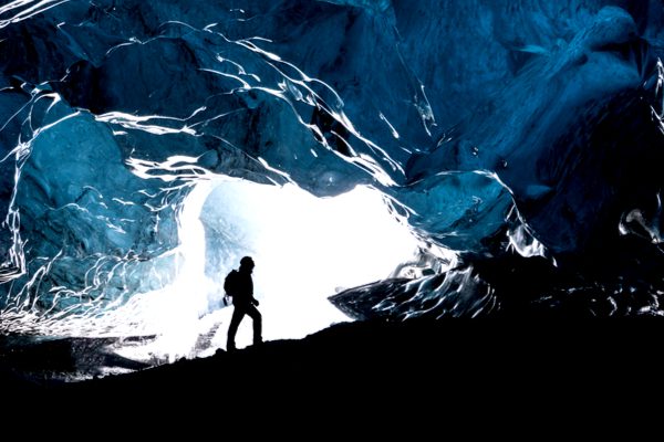 A man exploring a glacial cave