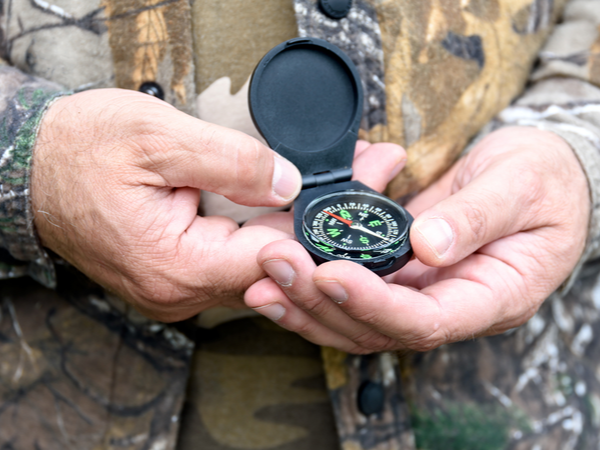 A soldier holding a compass in their hands