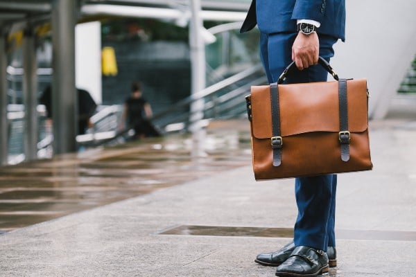 A man in a suit holding a leather briefcase