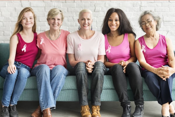 A group of women wearing breast cancer badges