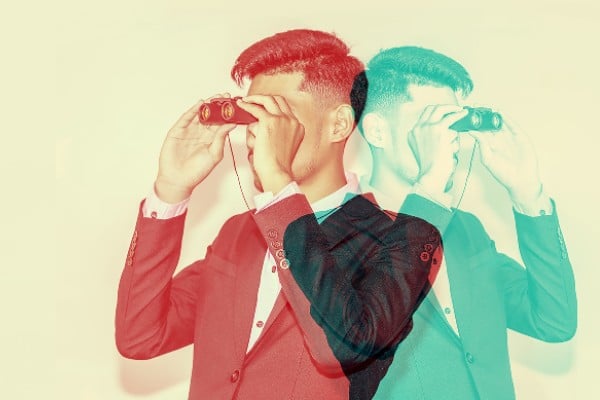 A man with binoculars looking in different directions