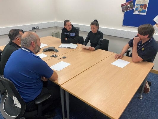A photo of Anthony Moyle CMgr, in a meeting with his colleagues at South Wales Police