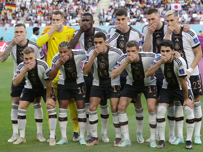 The German football team covering their mouths at a game during the Qatar 2022 World Cup