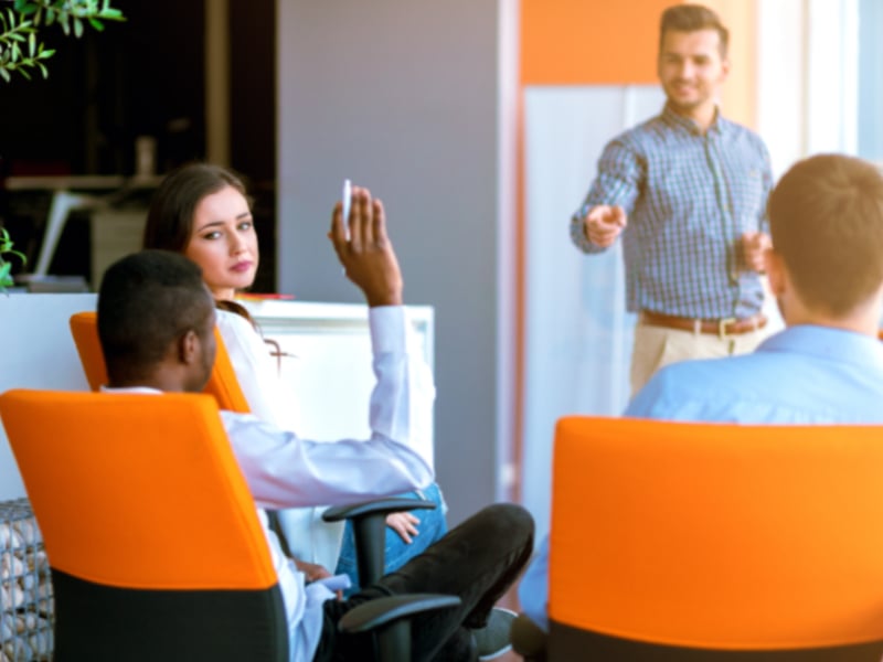 A person with their hand up asking a question