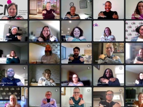 CMI staff making the Embrace Equity sign with their arms for International Women's Day 2023