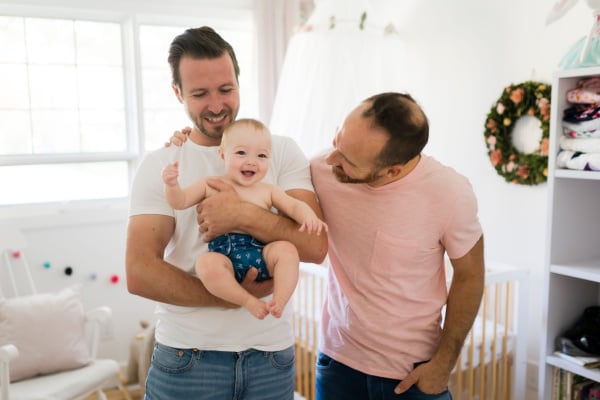 A couple holding a baby in their home