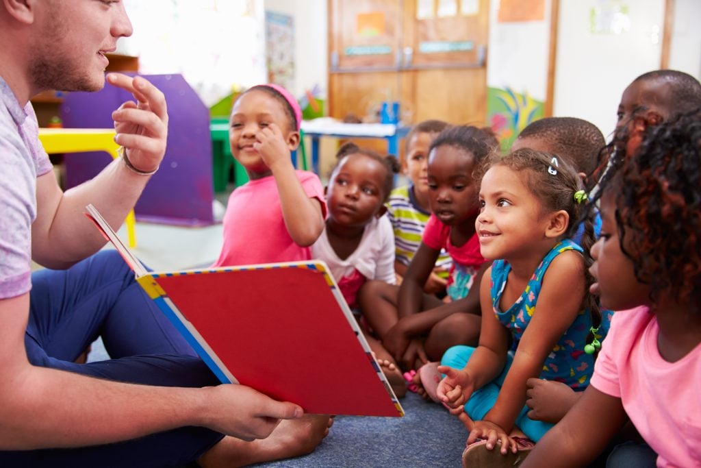 A volunteer reading to a group of children