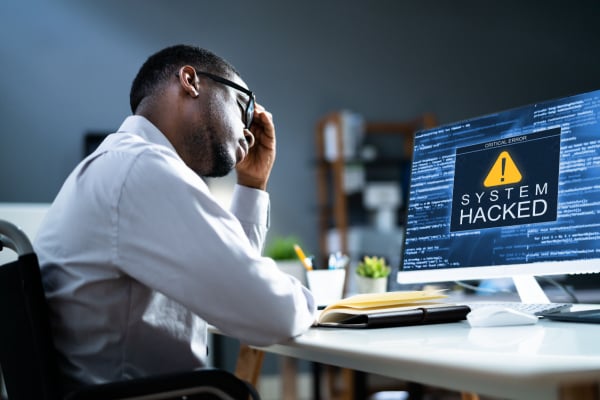 Man staring at his computer after being hacked