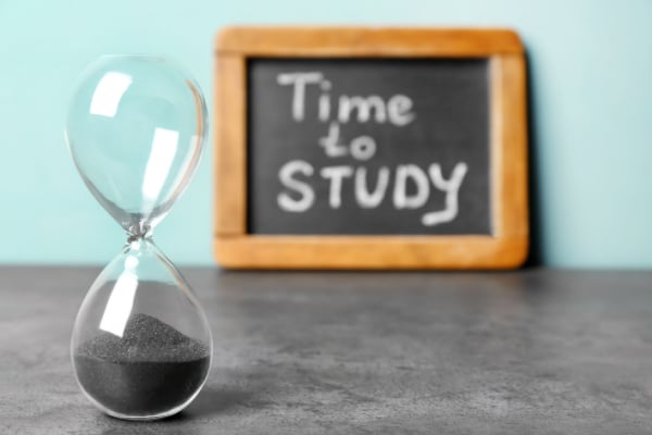 Picture of hourglass in front of a time to study sign