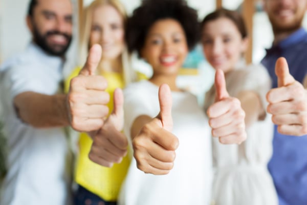 Group of people holding a thumbs up to the camera