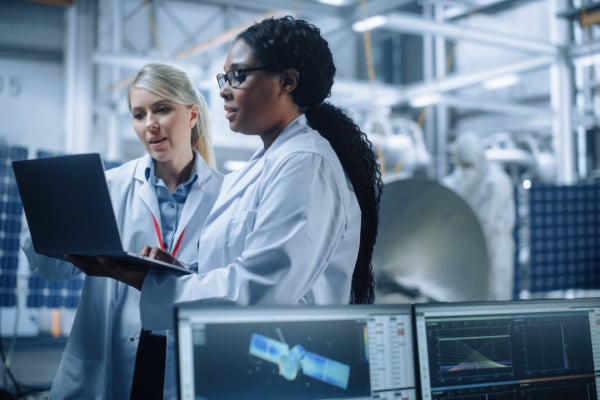 Two female engineers in discussion while using a computer