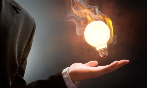 A person holding a lightbulb on fire