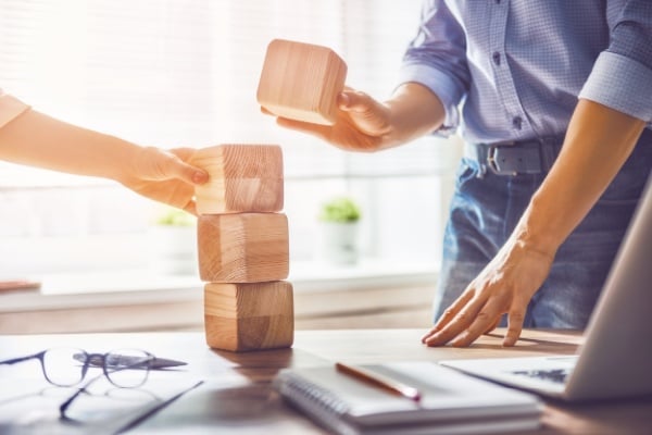 A group of people building a jenga tower