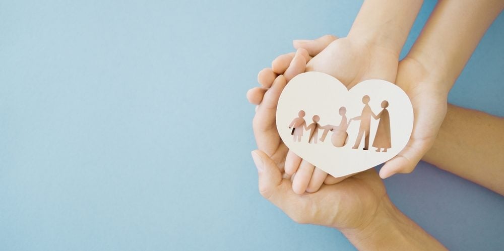 Hands holding diversity family in heart shape
