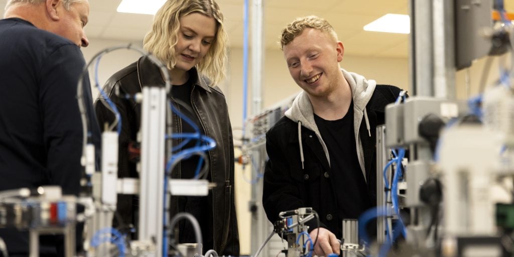 Two students and a course leader at work