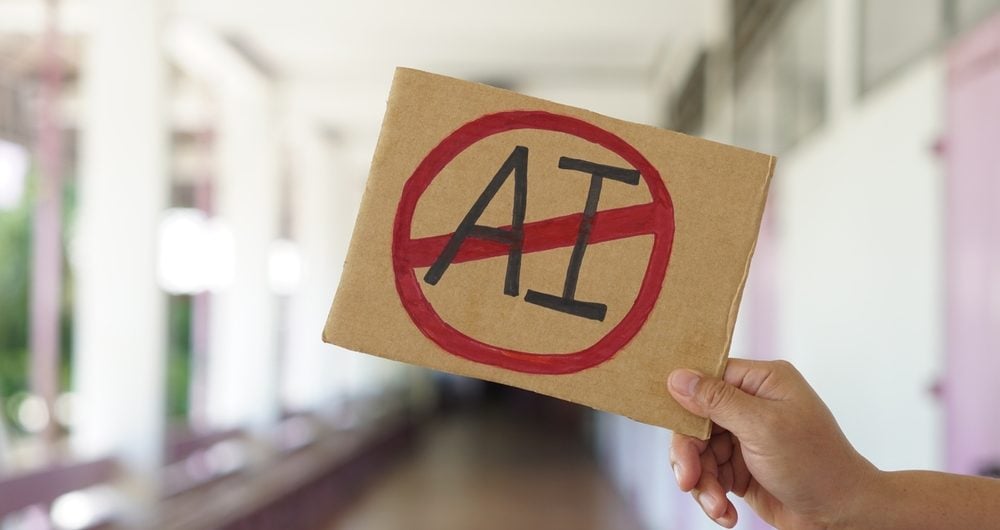 Person holding sign with AI crossed out