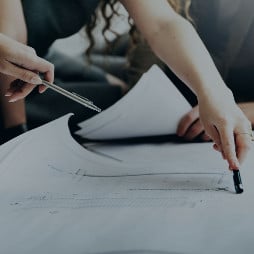 A group of people looking over some plans on a desk