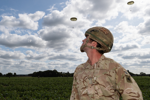 A soldier watching parachutes come down