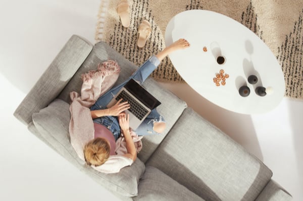 A lady sat working on her laptop in her living room