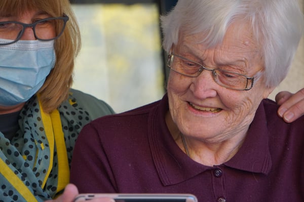 A carer comforting and elderly lady