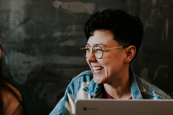 Woman laughing infront of laptop